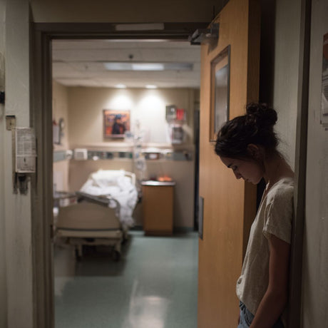 young woman leaning on a wall in the hallway of a hospital