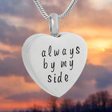 Silver heart-shaped cremation urn pendant engraved with "Always by My Side" on a chain, front view